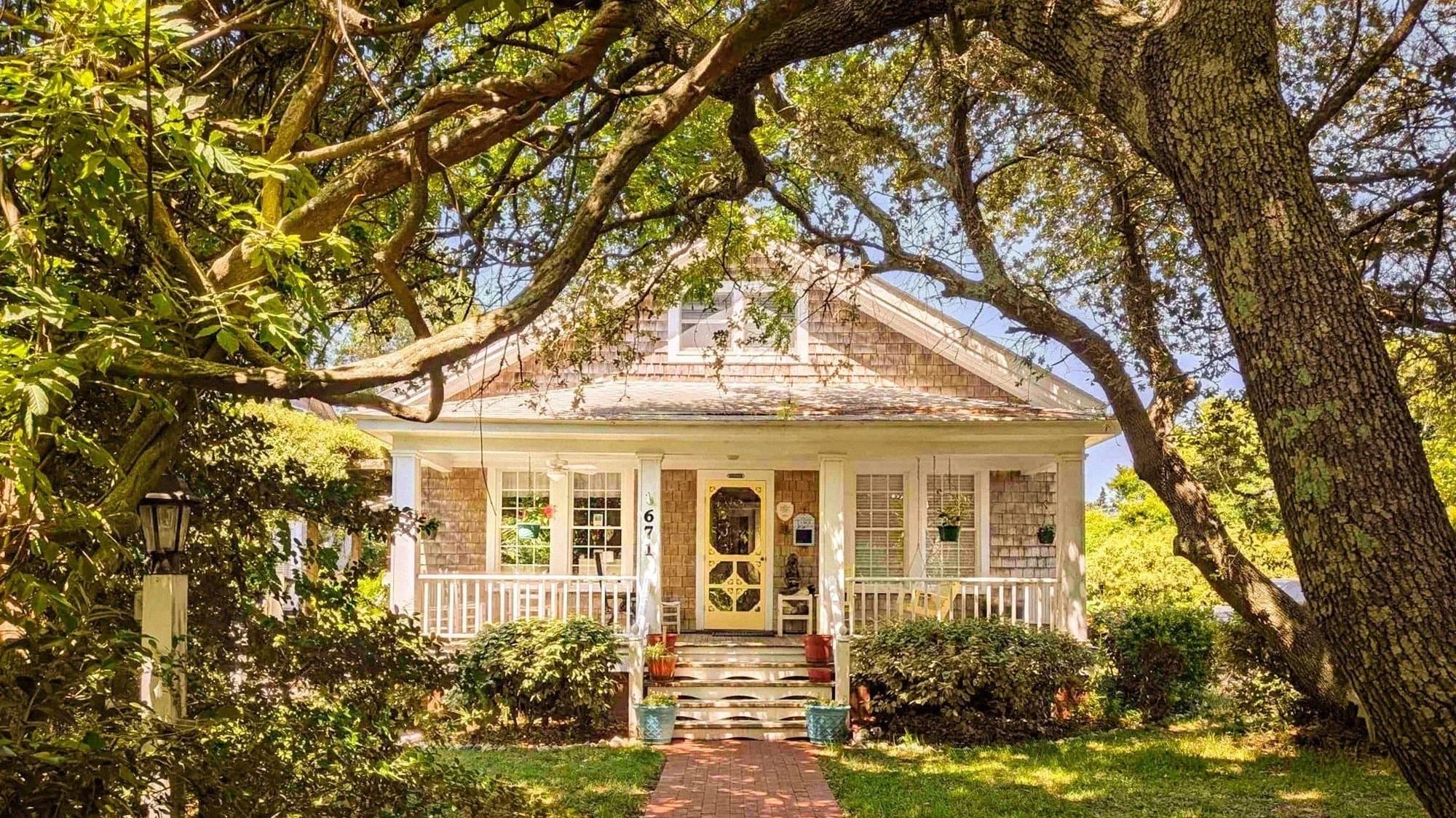 The front porch of Thurston House Inn, shaded by a century-old oak tree on Ocracoke Island